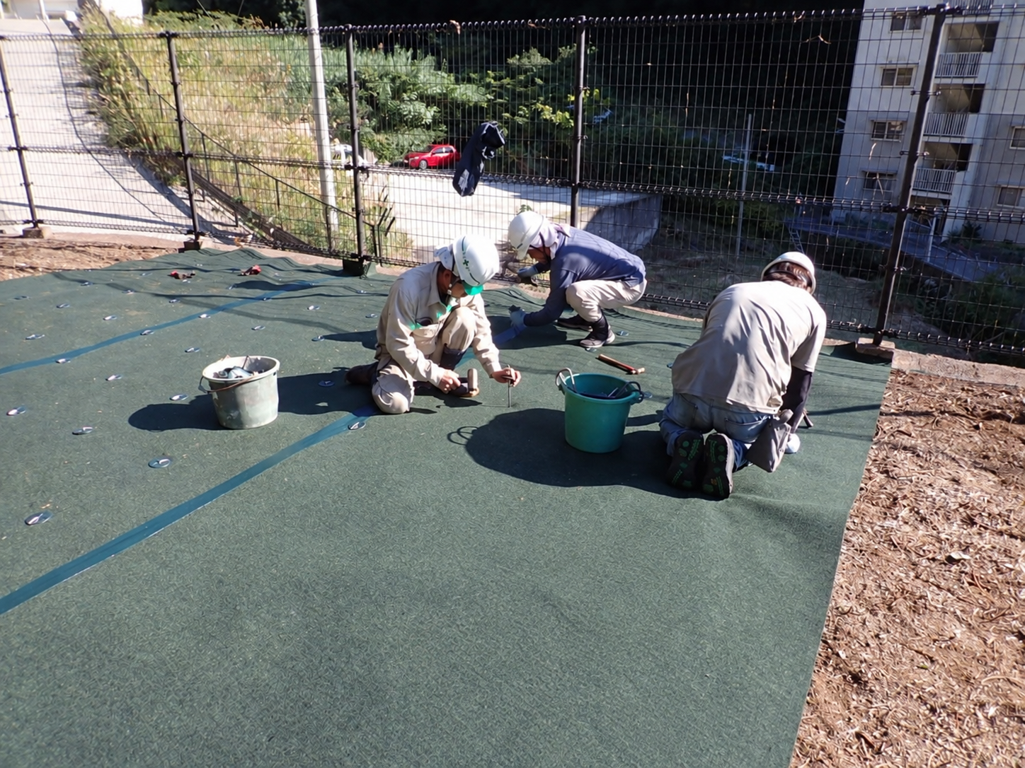 複数のスタッフによる防草シートの敷設作業|金子兄弟造園